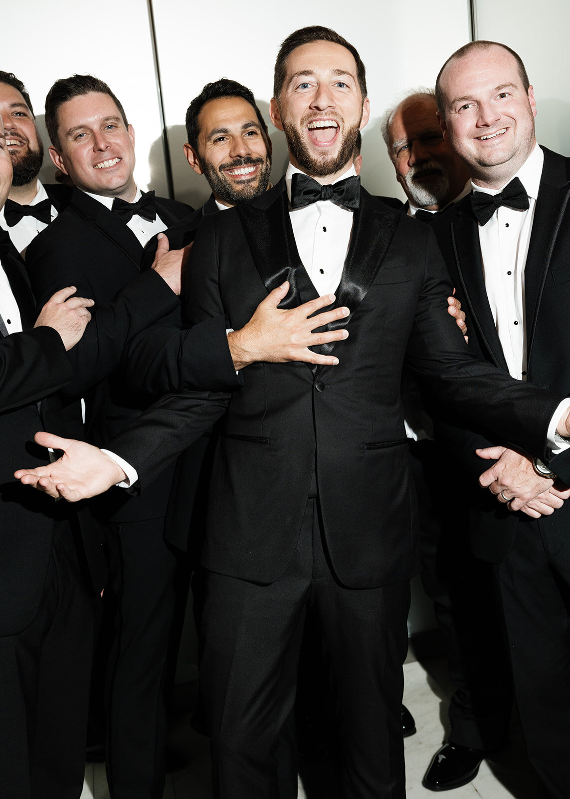 a group of men cheering in wedding suits