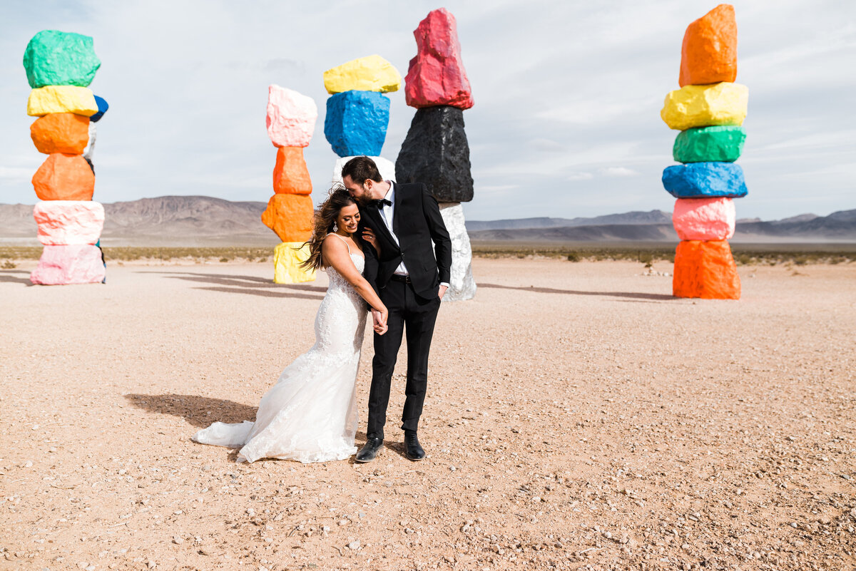 Stunning wedding couple posing at the seven magic mountains in  Las Vegas