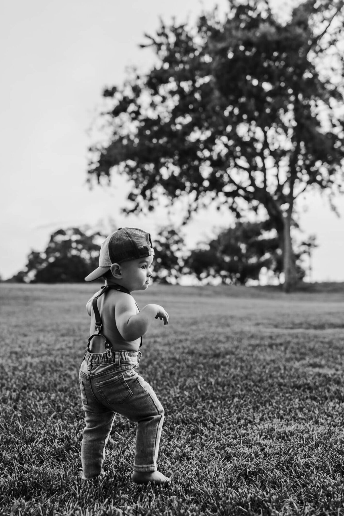 black and white photo of baby boy walking at park for allyson blankenburg
