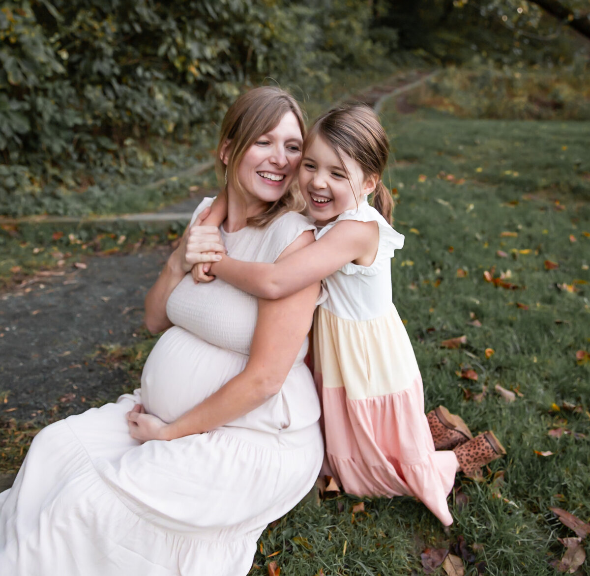 A child giggles with her Mom whispering her secret as the photographer makes them laugh in Harford County, MD