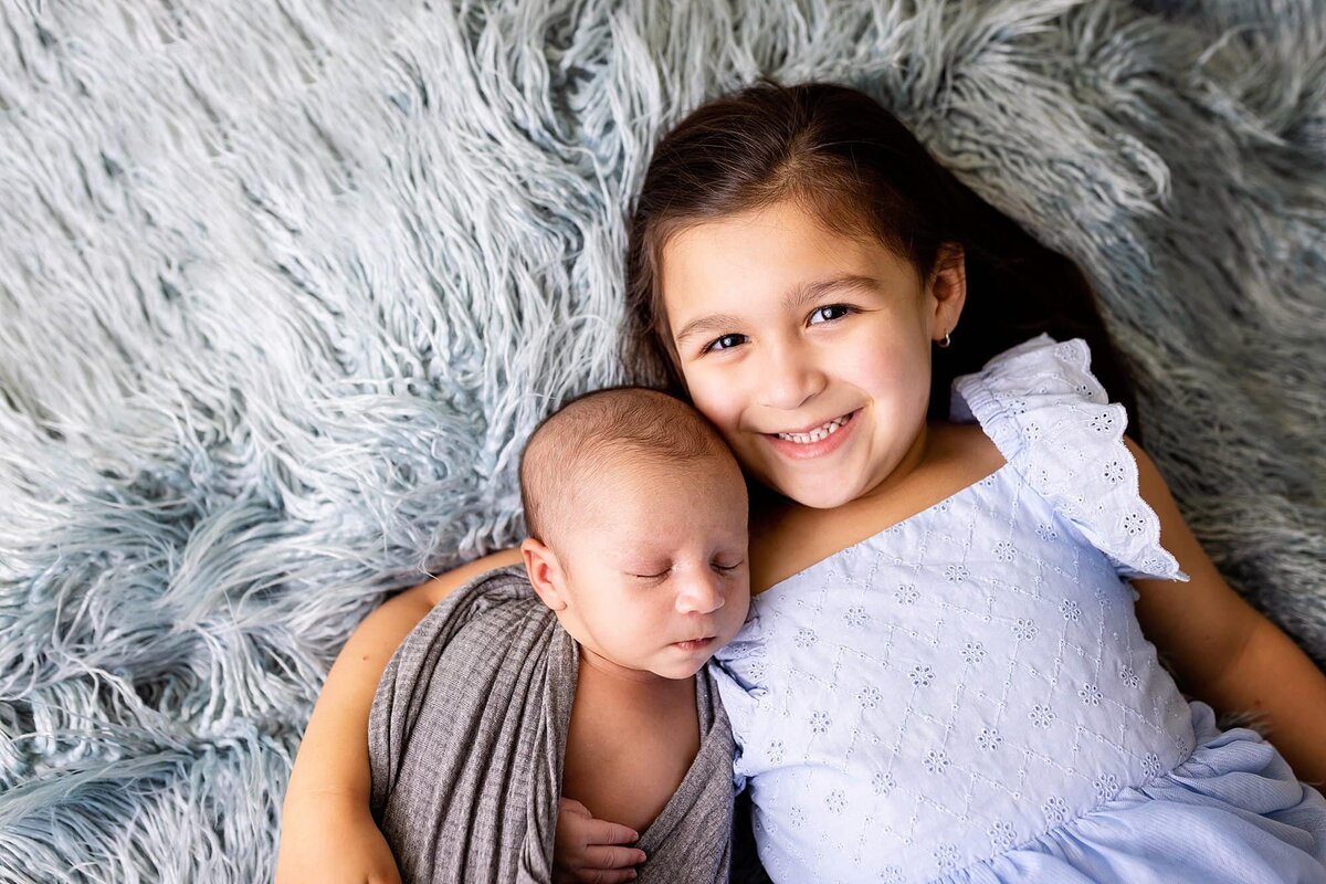 Newborn grey swaddle with older sister