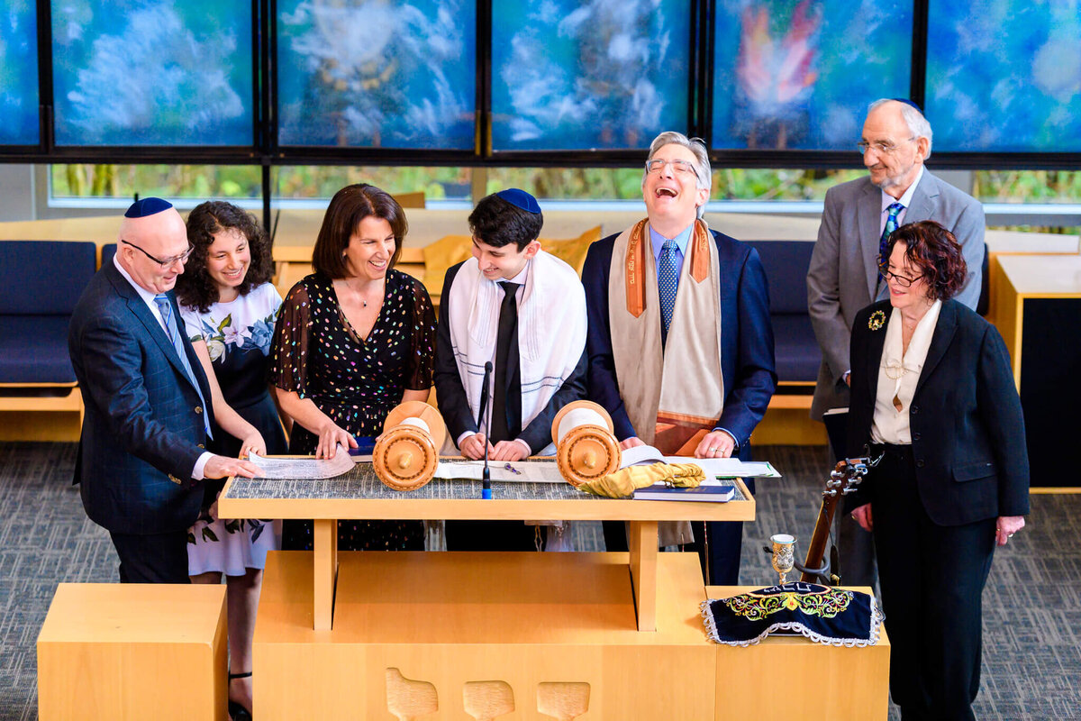 A family laughs together while giving a speech during a bar mitzvah