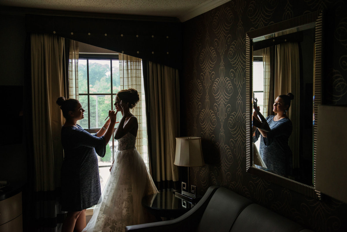 Bride getting ready in window at The Inn at Fox Hollow