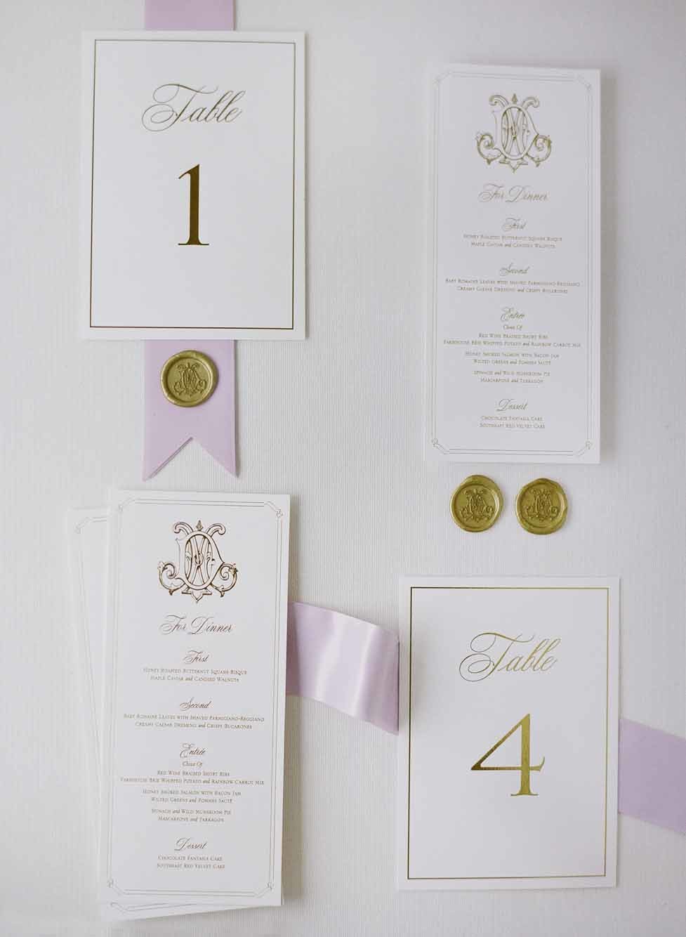Beautiful wedding invitation suite flat-lay  with gold and purple accents.