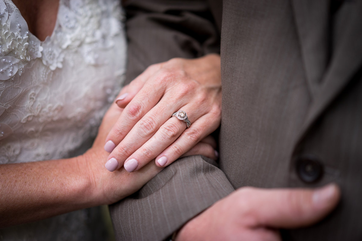 bride holding grooms arm showing wedding ring detail in texas hill country san antonio wedding
