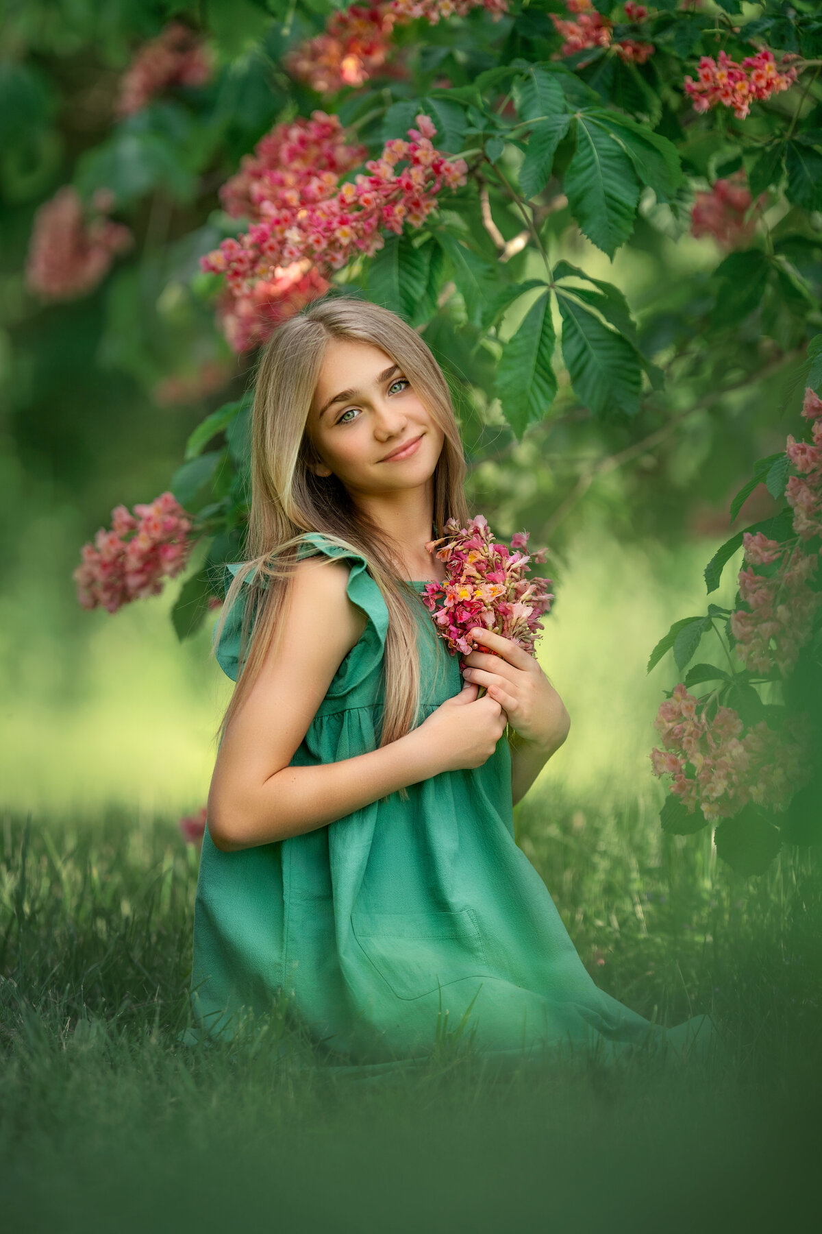 big green eye blond girl in mint color dress from Target is holding pink tree blossoms.