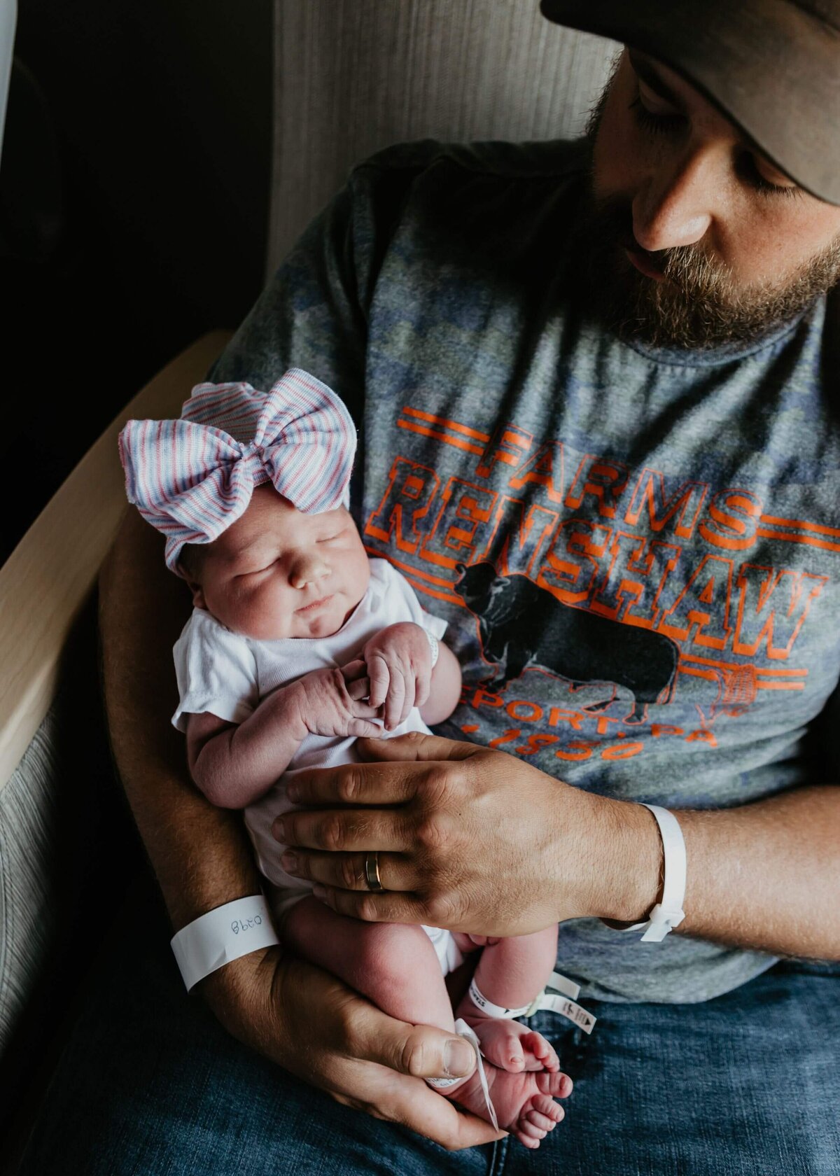 Pittsburgh newborn photographer captures a new father  cradling his baby.