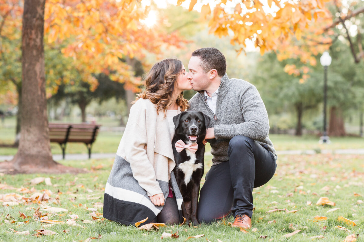 Couple kissing in the Boston Public Garden with their dog in the Fall