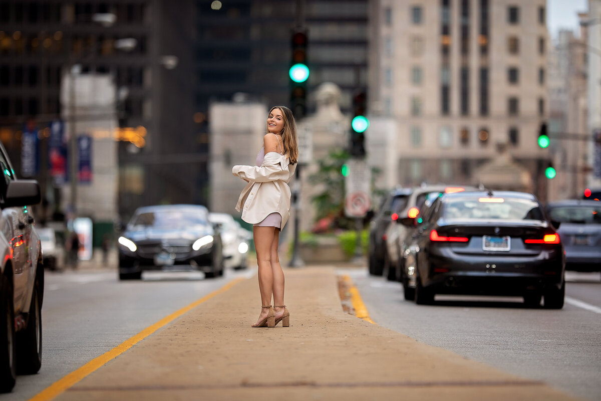 High school graduate poses in the middle of busy Chicago street