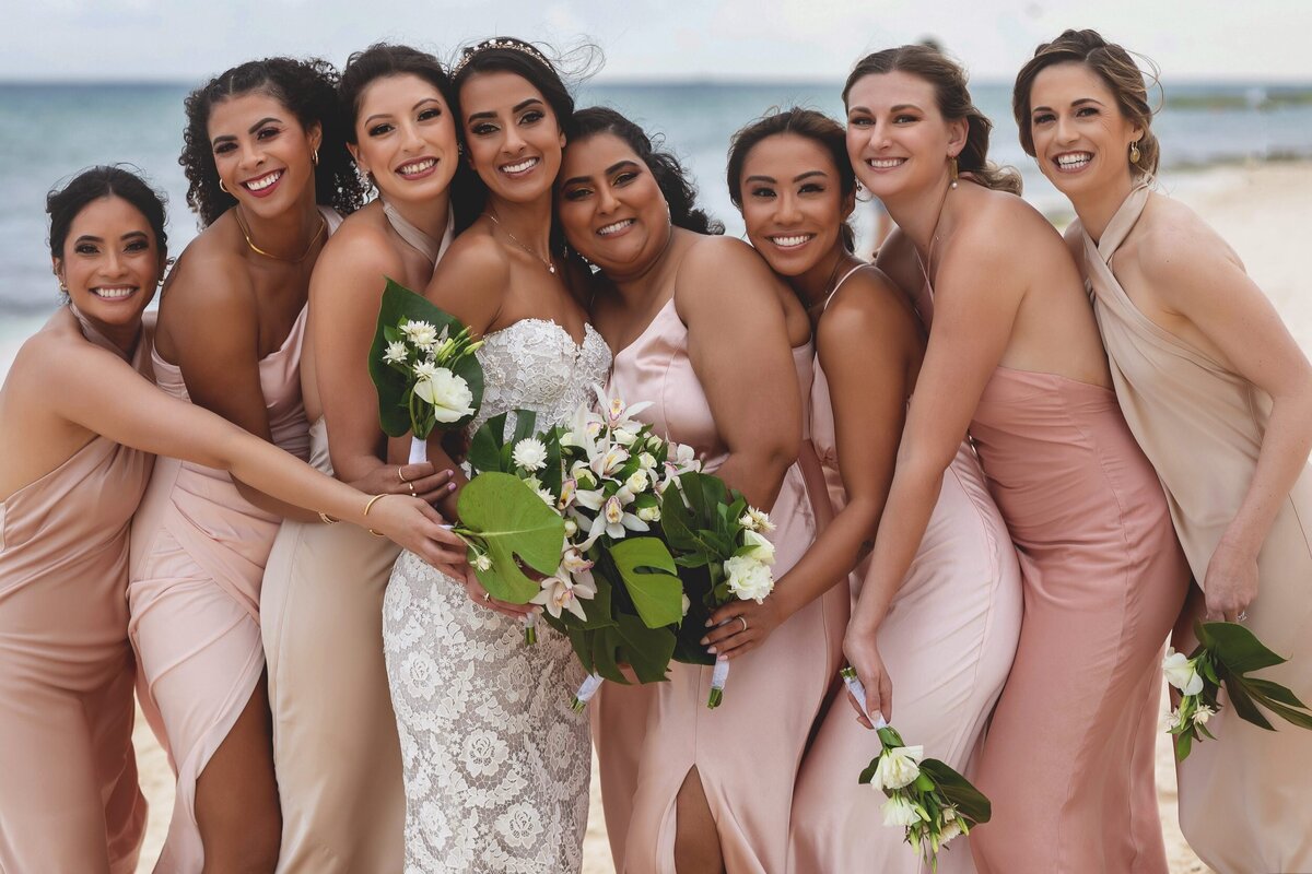 Bride and bridesmaids laughing on beach  Riviera Maya wedding.