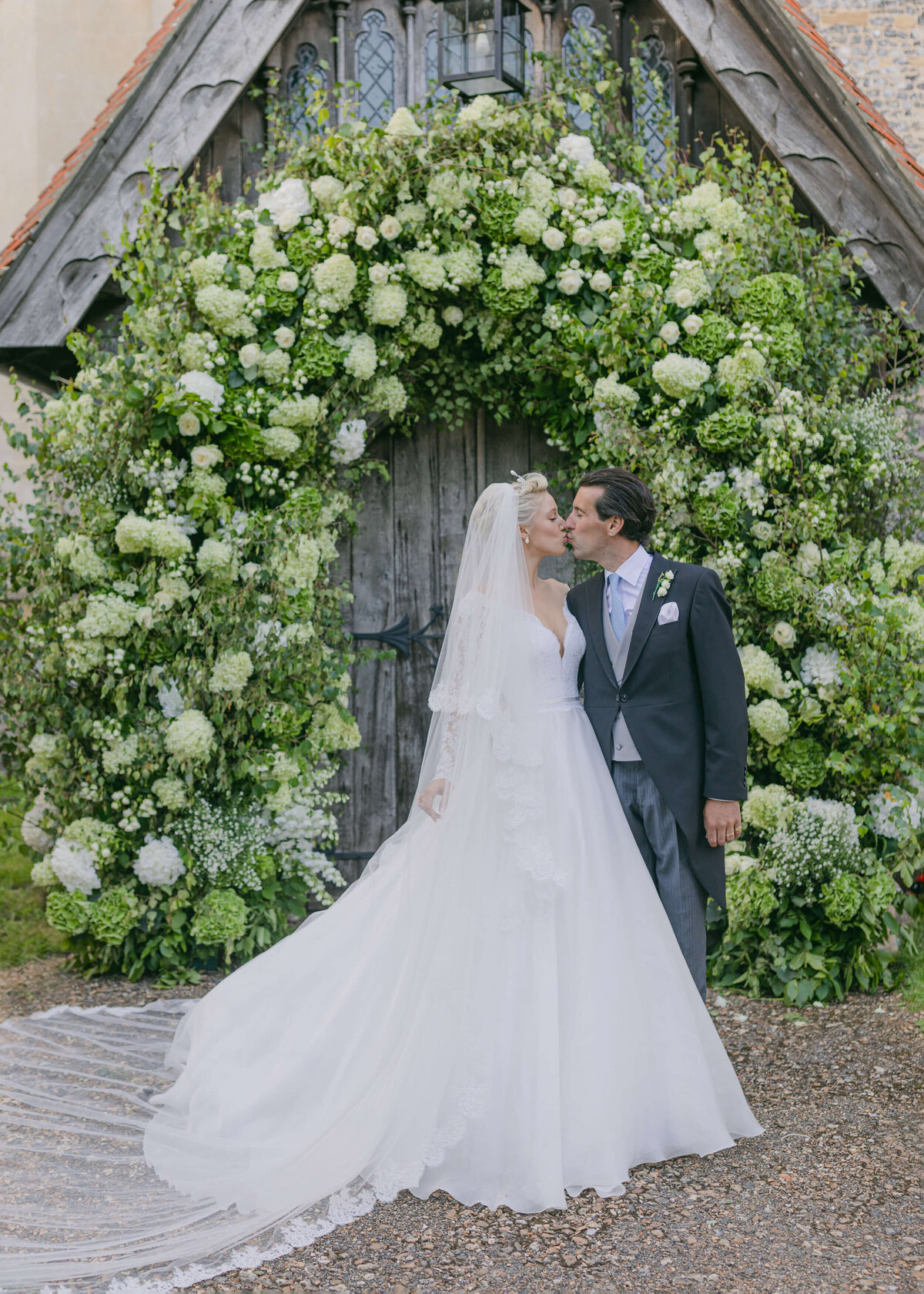 chloe-winstanley-weddings-hambleden-church-flower-arch-suzanne-neville-kiss