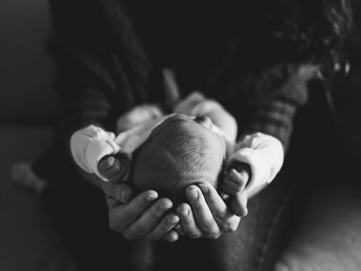Black & white image of a newborn nestled in her mother's hands taken by Los Angeles newborn photographer Marjorie Cohen.