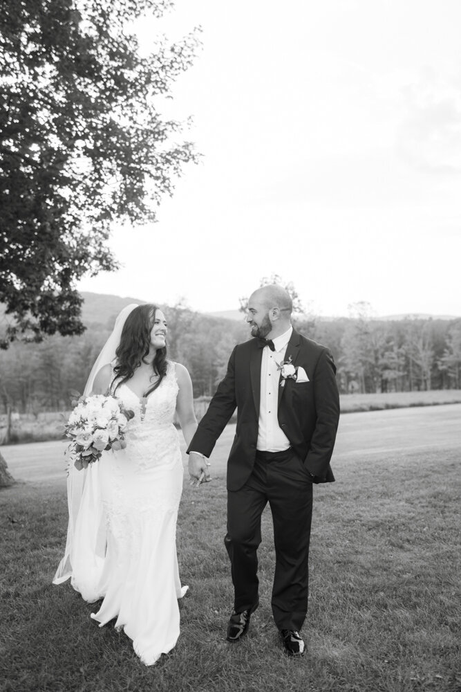black and white portrait of bride and groom in grassy field - candlelight farms inn wedding