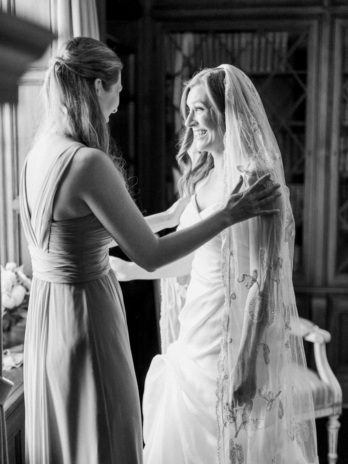 a bride putting on her wedding veil by annie eckstrom bridal