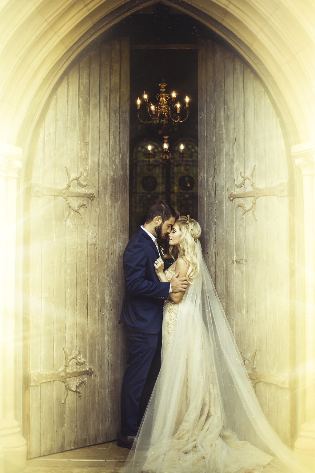 Wedding Photograph Of Bride in Her Wedding Dress and Groom in His Blue Suit Kissing at the Door of the Church Los Angeles