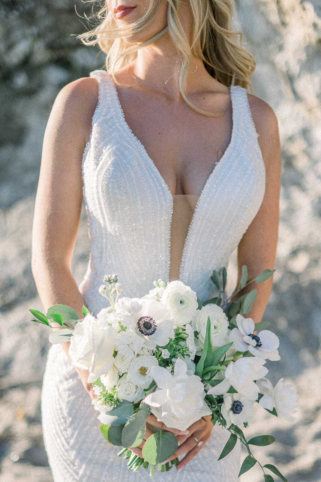 Bride on the beach with white wedding bouquet at Dolphin Bay Resort in Pismo Beach, CA