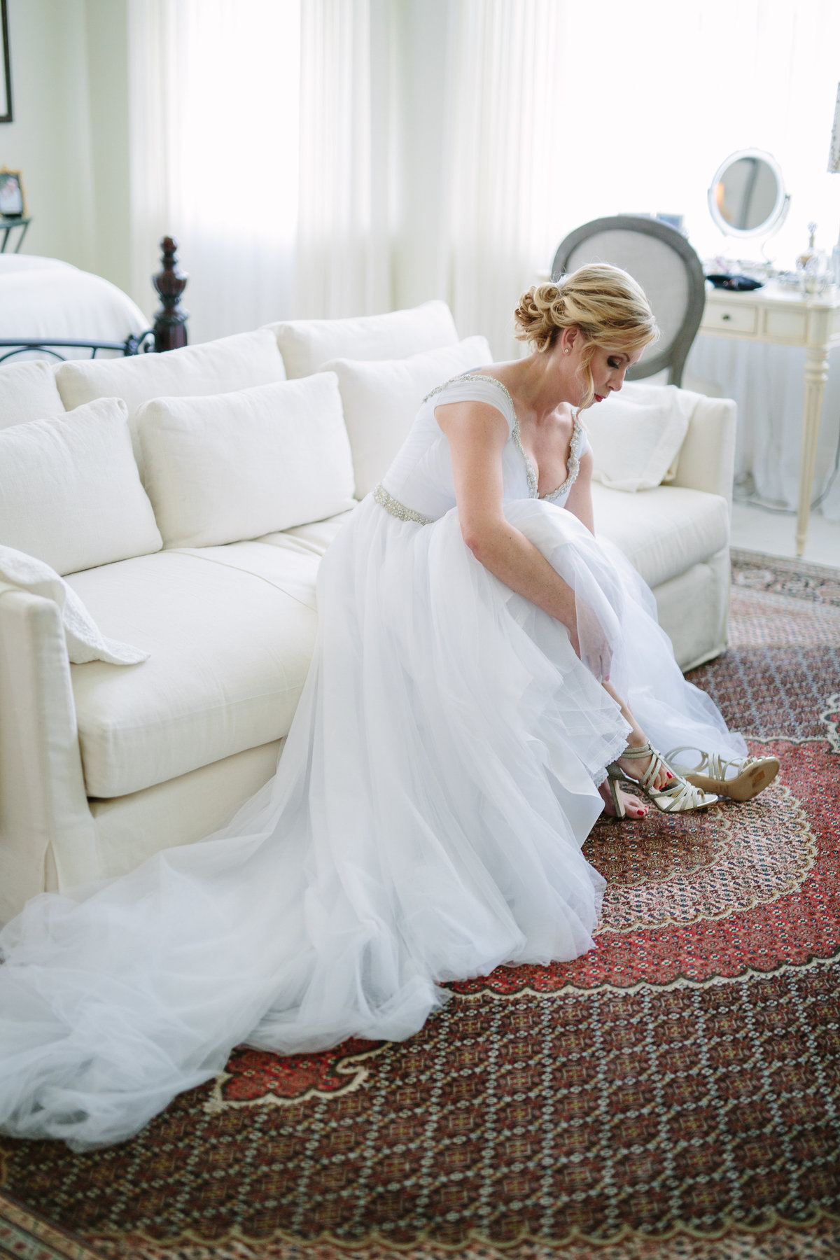 Bride putting her wedding shoes on during getting ready at home in San Antonio