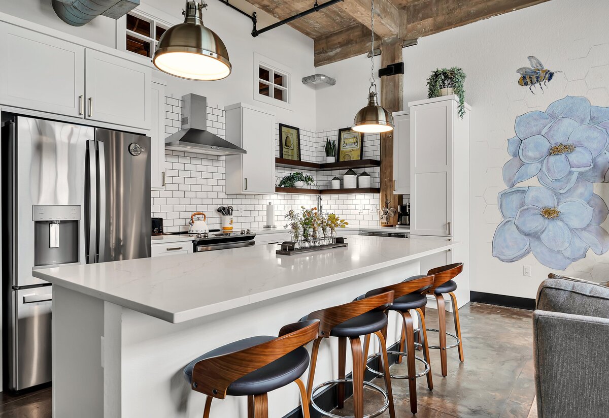 Kitchen island with bar height seating for four in this one-bedroom, one-bathroom vintage condo that sleeps 4 in the historic Behrens building in the heart of the Magnolia Silo District in downtown Waco, TX.