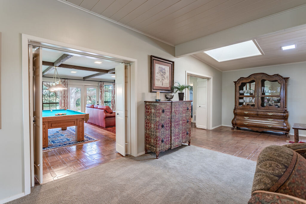 Large living room opening to a pool table in this 5-bedroom, 4-bathroom vacation rental house for 16+ guests with pool, free wifi, guesthouse and game room just 20 minutes away from downtown Waco, TX.