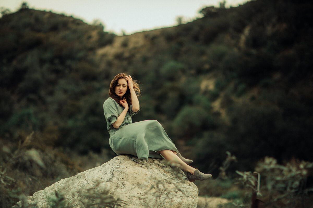 Portrait Photo Of Young Woman In Green Dress Seated On a Rock Los Angeles
