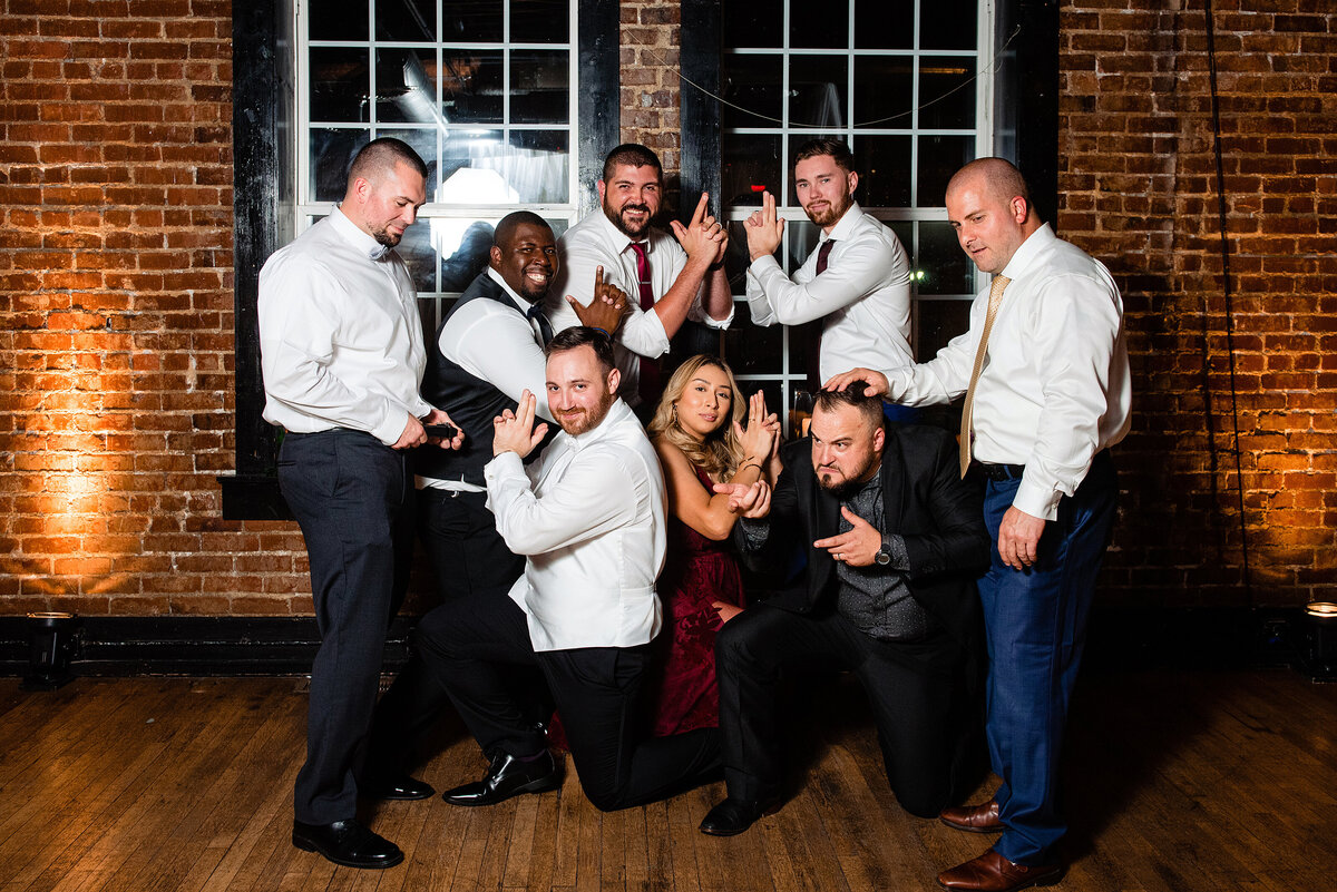Groom with his friends posing fun for a group photo at reception