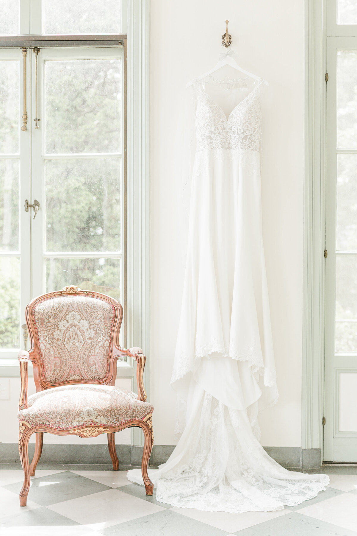A wedding gown hangs for a detail image.