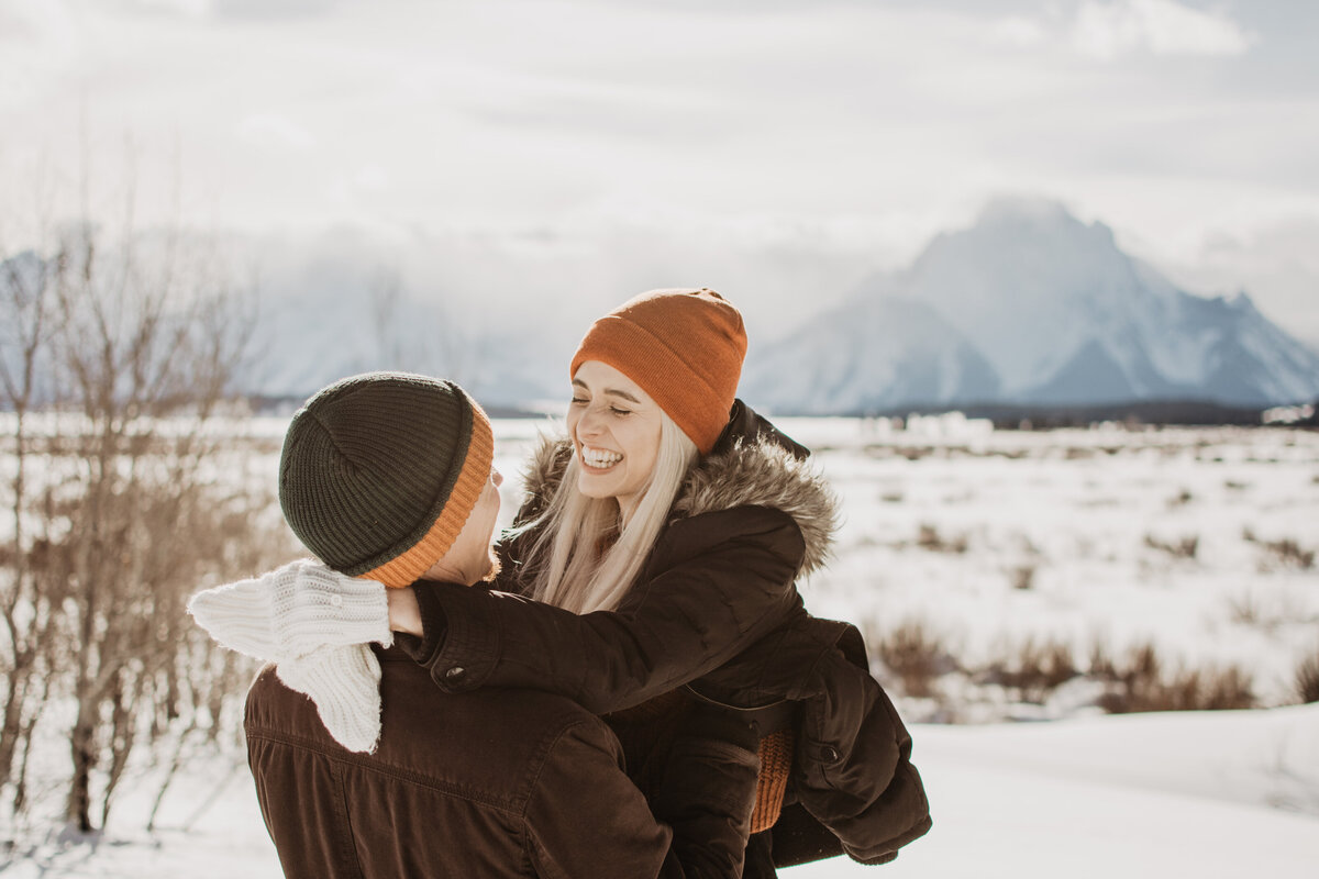 woman smiling at her fiance as she holds her arms around his neck in Jackson Hole for their engagement session with jackson hole photographers