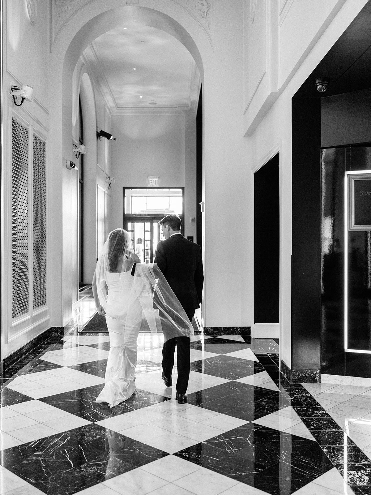 Bride and groom walking through hotel lobby in washington DC