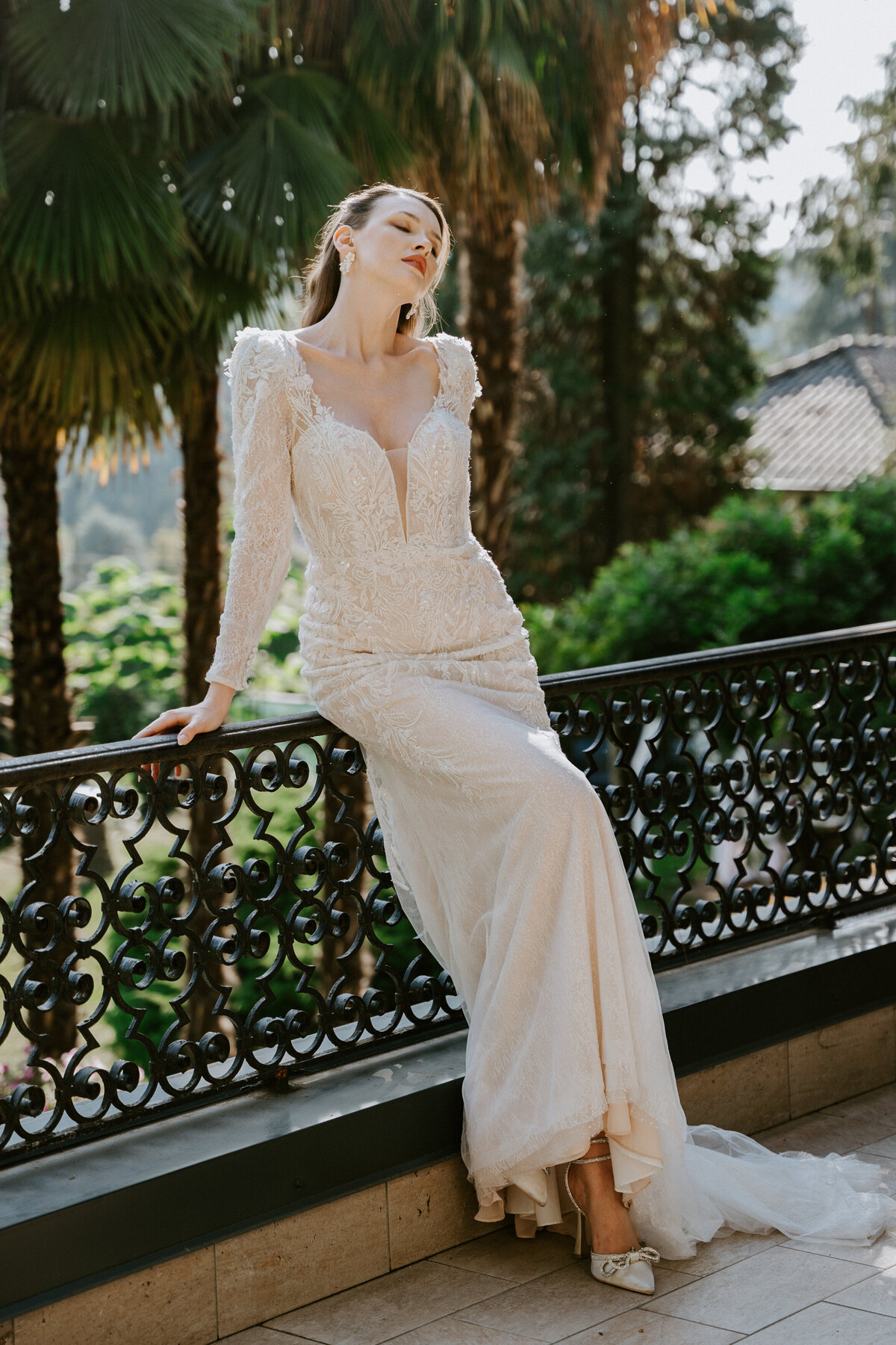 Bride standing on balcony of Villa Sofia near Lake Como in Pronovias dress