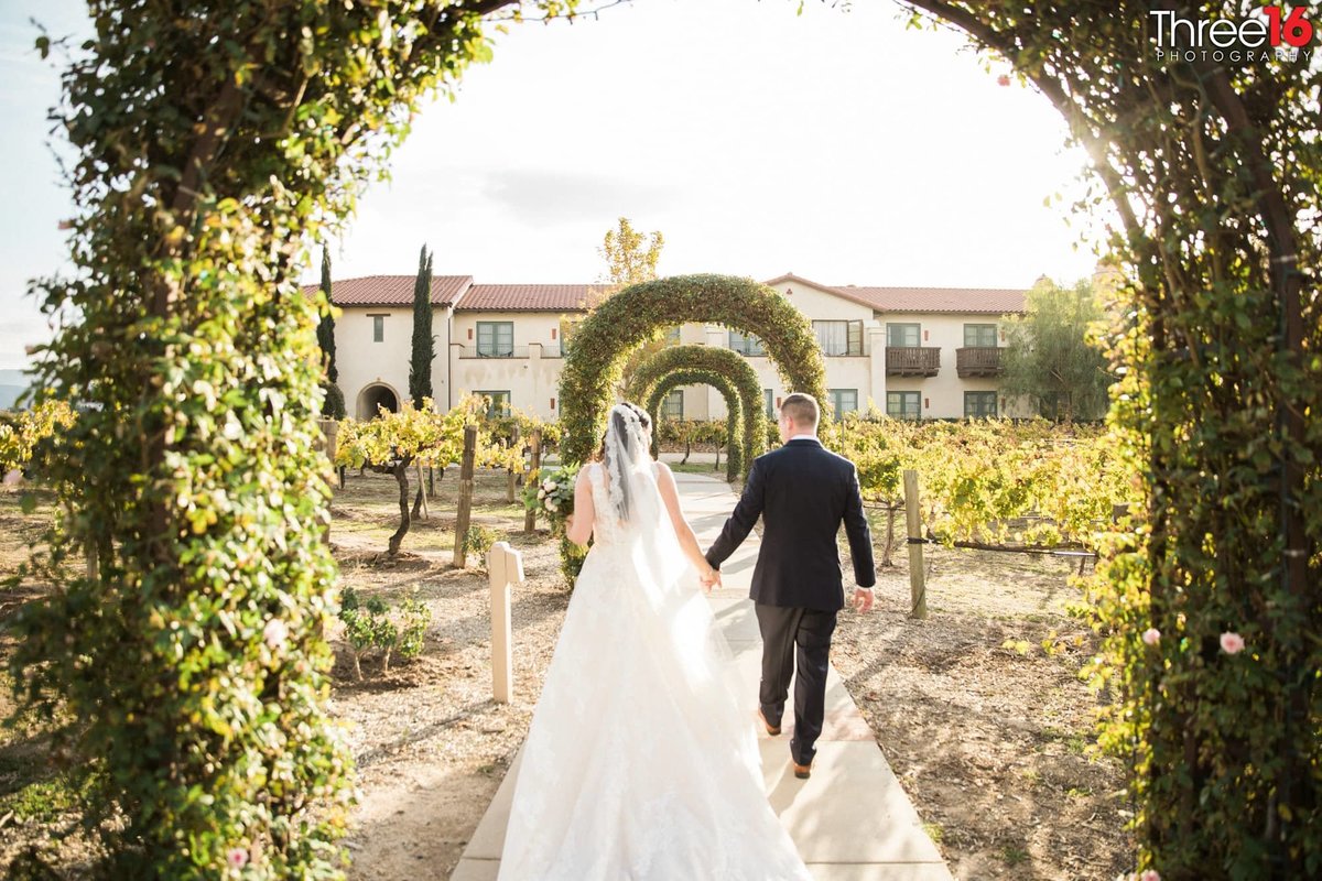 Bride and Groom walking under arch ways at Ponte Winery