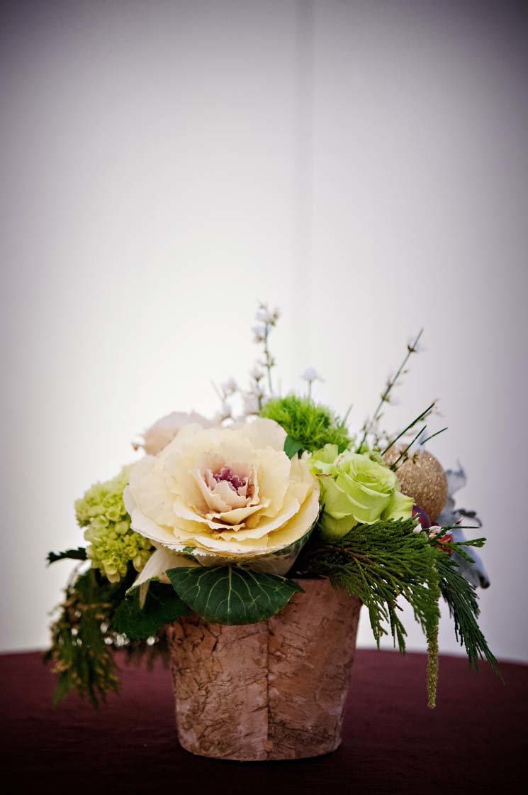 winter centerpiece of roses in barked vase for holiday party