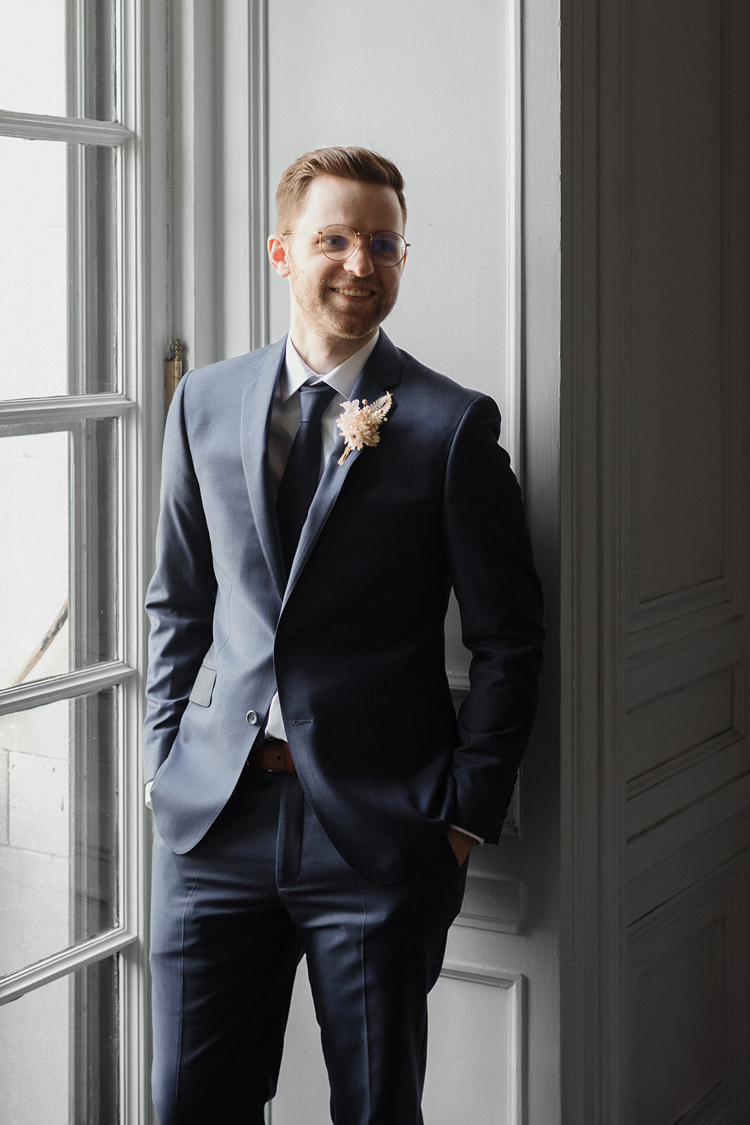 Just Married photo session groom has hands in pockets and looks toward the bride off camera and laughs