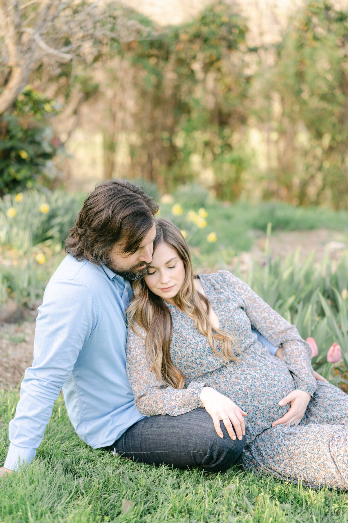 pregnant mom cuddling husband in asheville backyard