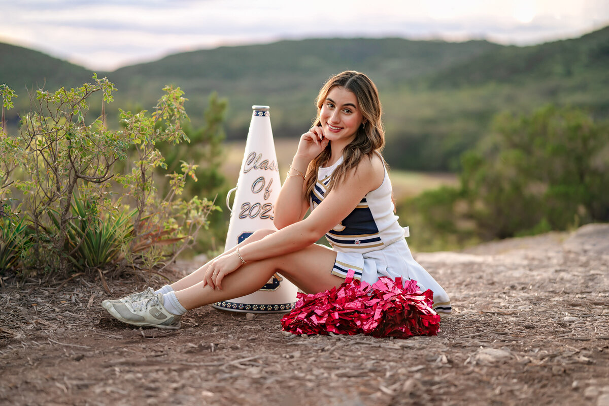 Senior photography of a cheerleader in her uniform at Madla Park overloook in San Antonio.