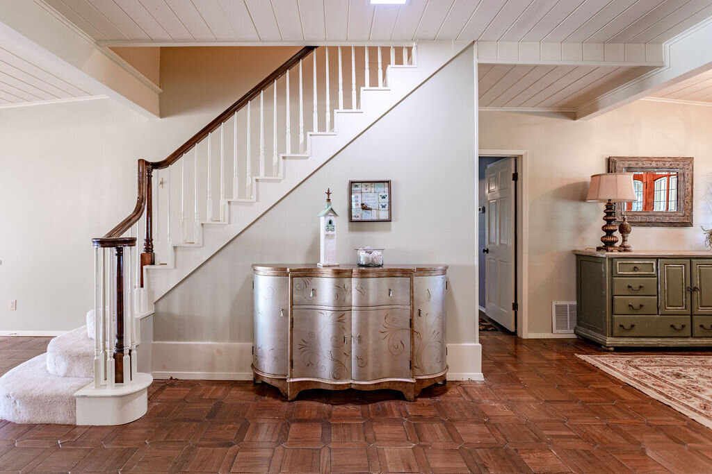 Beautiful staircase and professional decor in this 5-bedroom, 4-bathroom vacation rental house for 16+ guests with pool, free wifi, guesthouse and game room just 20 minutes away from downtown Waco, TX.