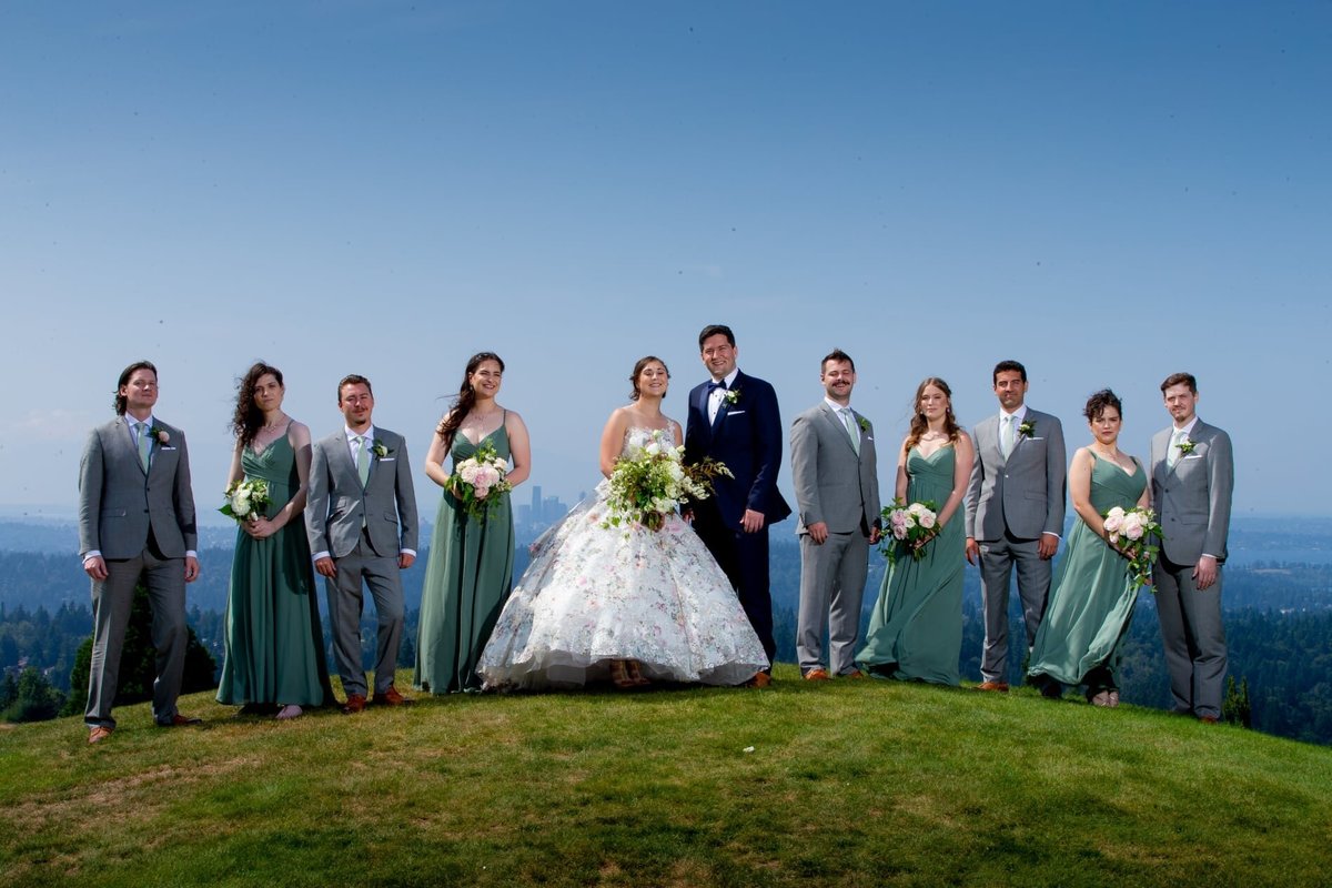 Bridal Party standing on hill at Newcastle Golf club with Seattle in background