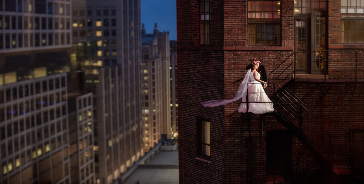 A Chicago wedding photographer captures the bride and groom on the fire escape at the Warwick Allerton hotel.