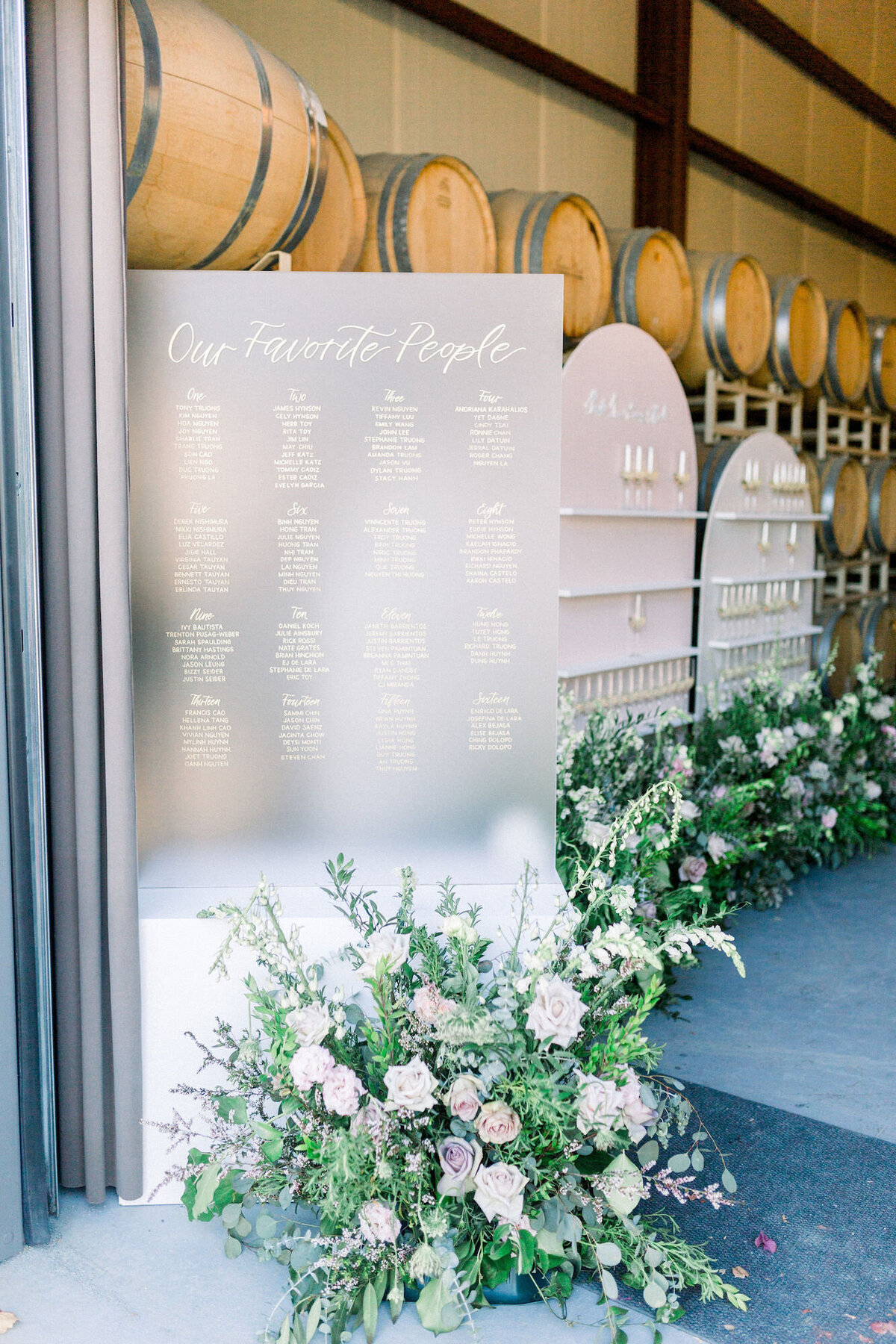 Tall frosted acrylic seating chart decorated with florals for a winery wedding