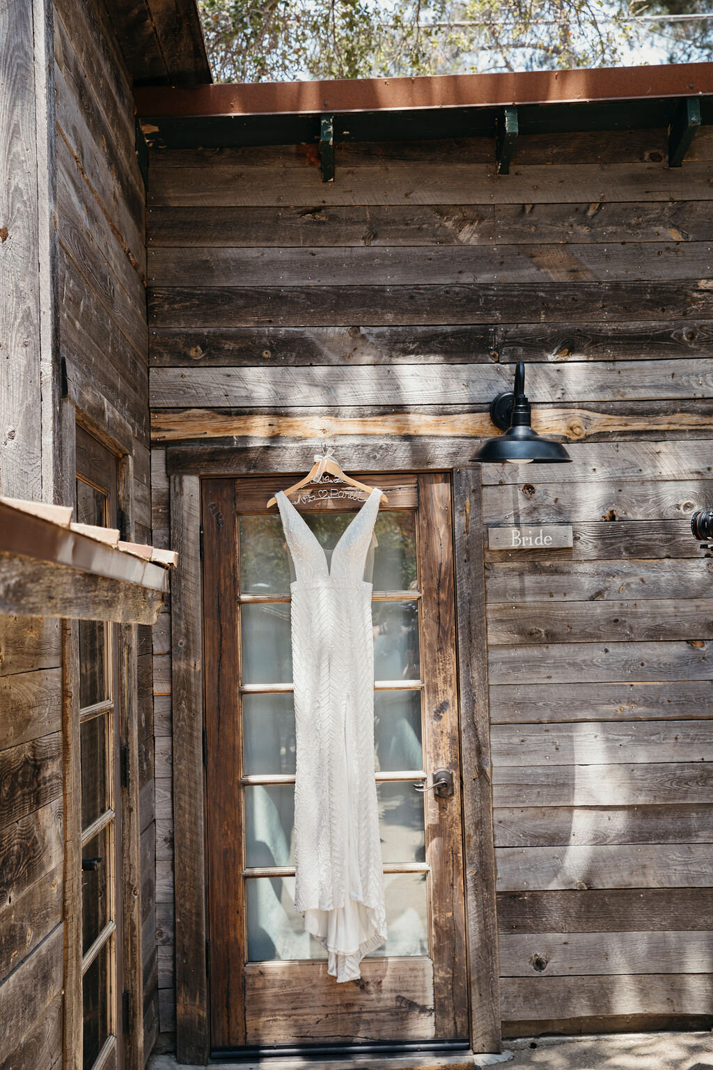 wedding dress hanging on reclaimed wood wall