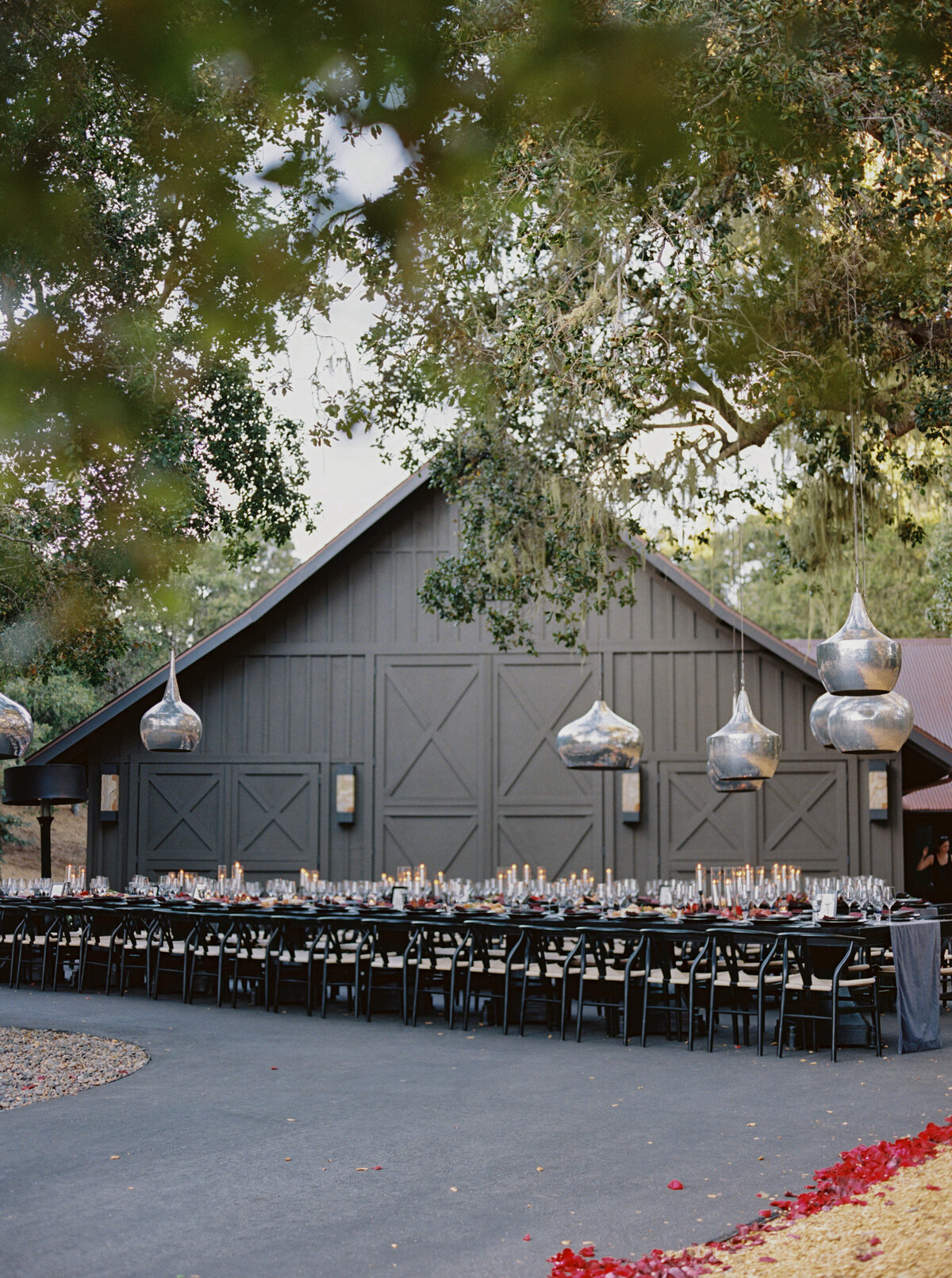 Long Tables and Hanging Lights  in front of a barn