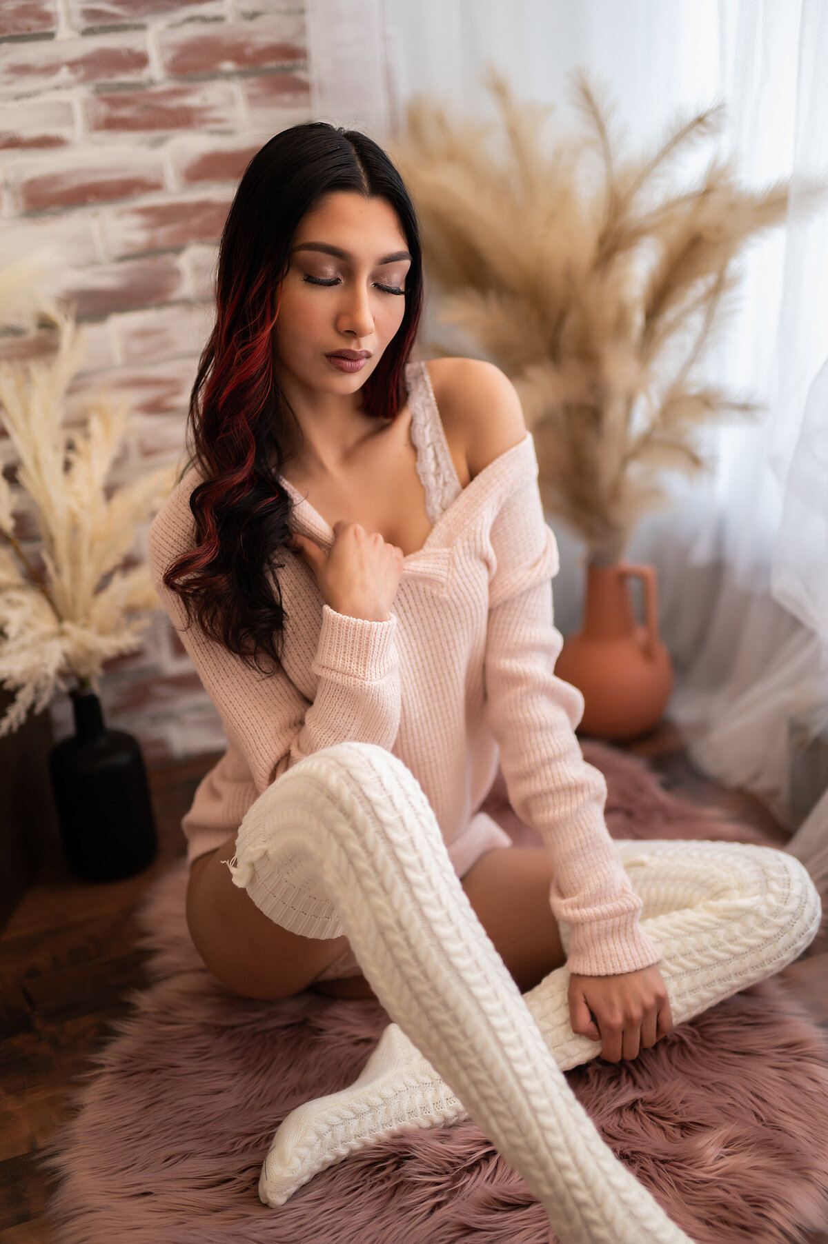 Boudoir portrait of a woman wearing knit tights and a sweater in our Waukesha photo studio.