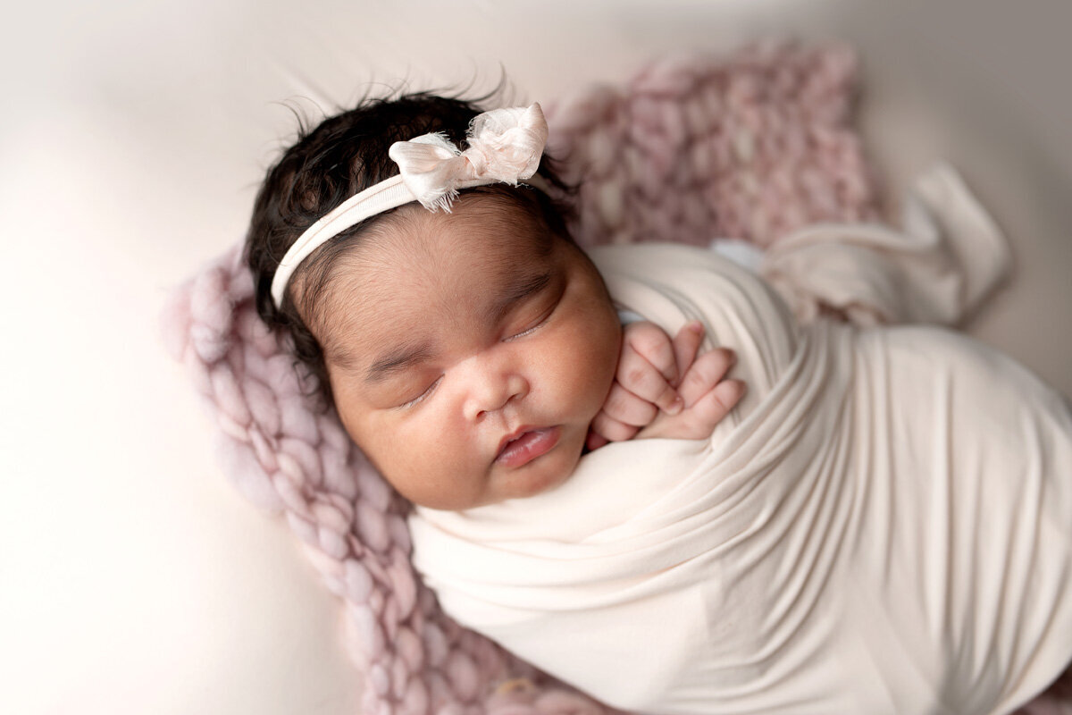 Newborn session of baby girl wearing a bow