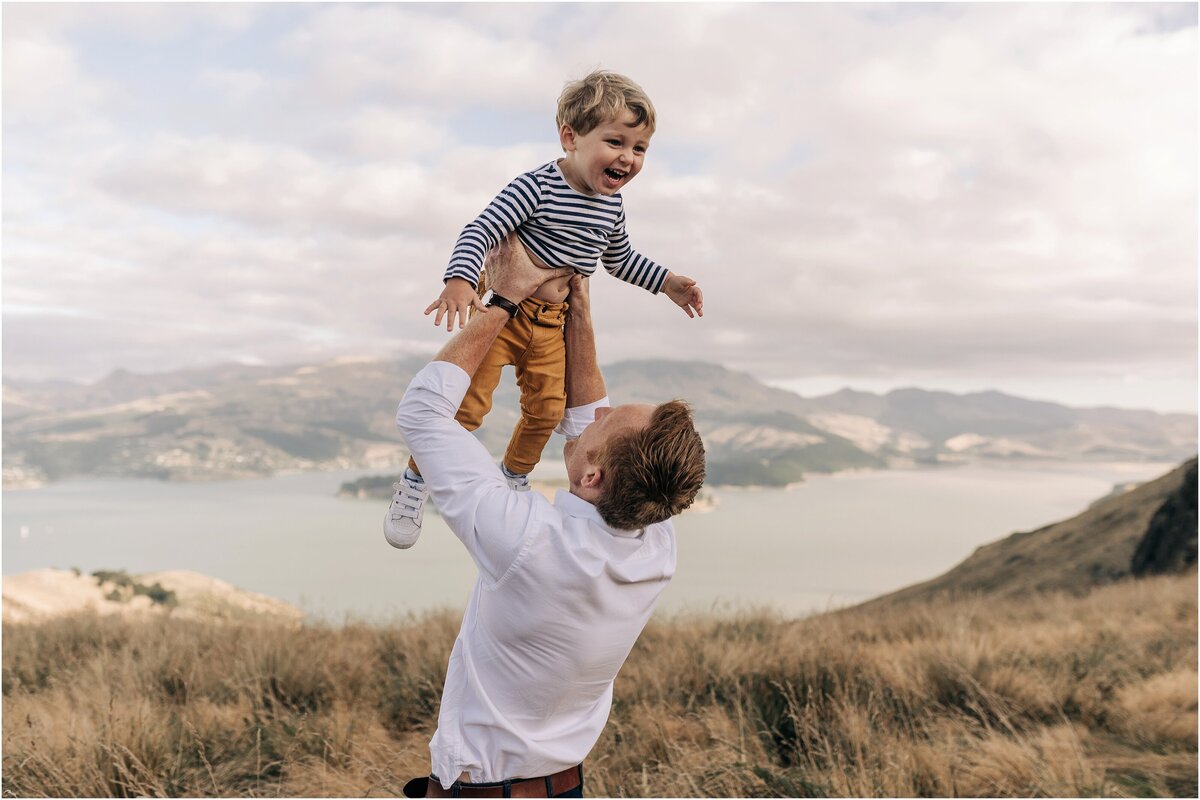 dad throwing child in air view lyttelton harbour family photos christchurch top port hills