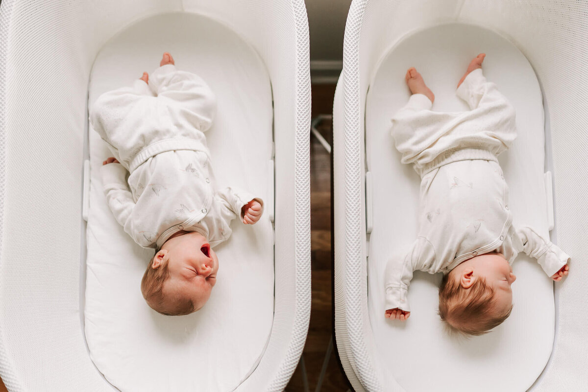 boy newborns sleeping side-by-side in their snoos