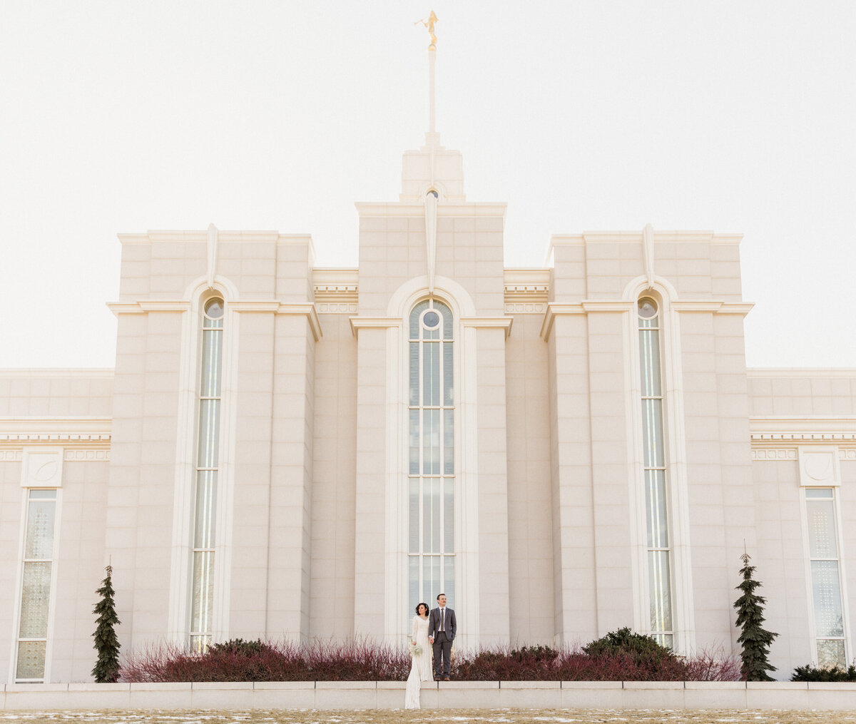 Utah Wedding Photographer takes a photo of the newly sealed bride and groom outside of the temple in a dramatic pose of them both looking opposite directions.