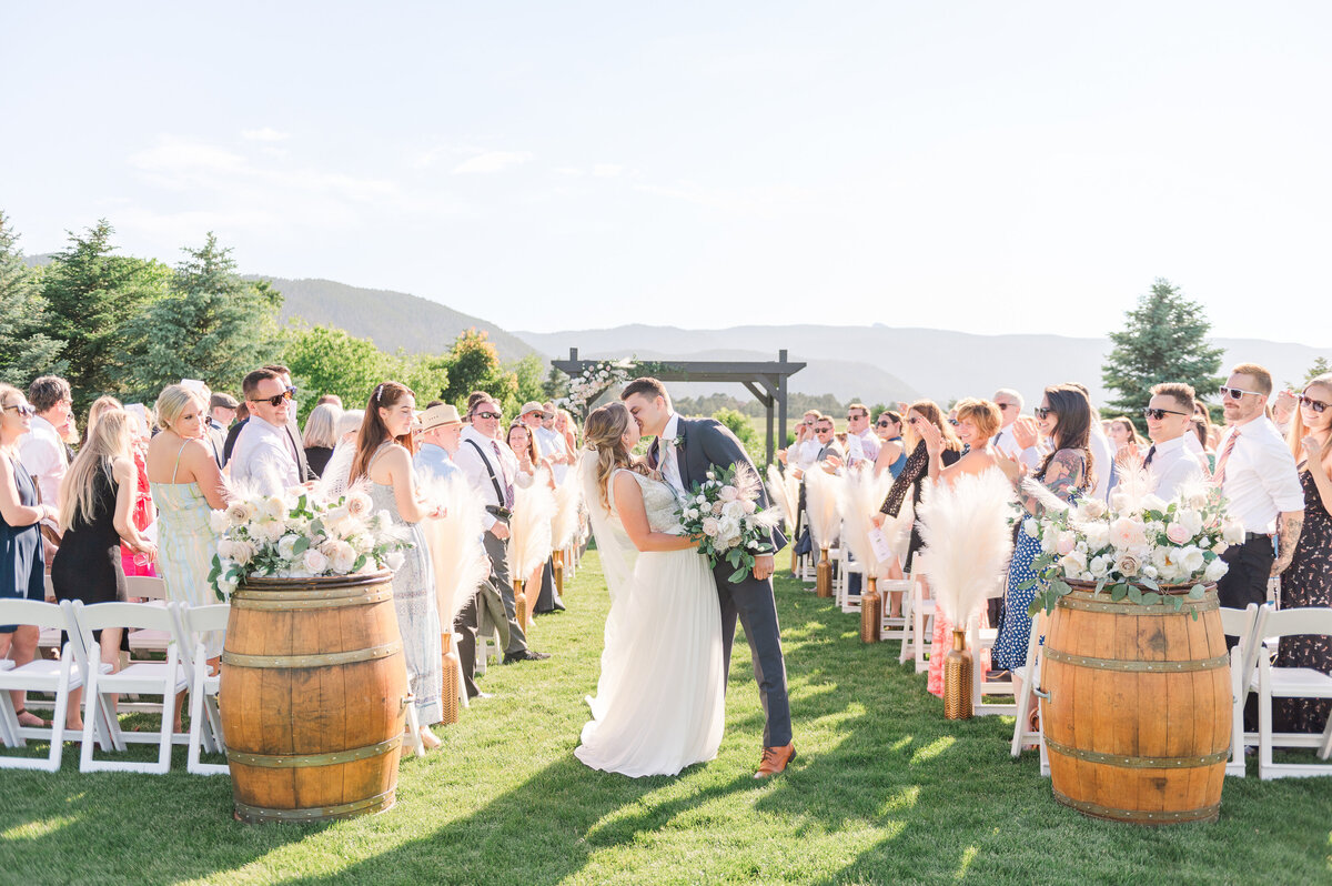 Couple kissing during the wedding exit at Crooked Willow Farms in Larkspur, Colorado.