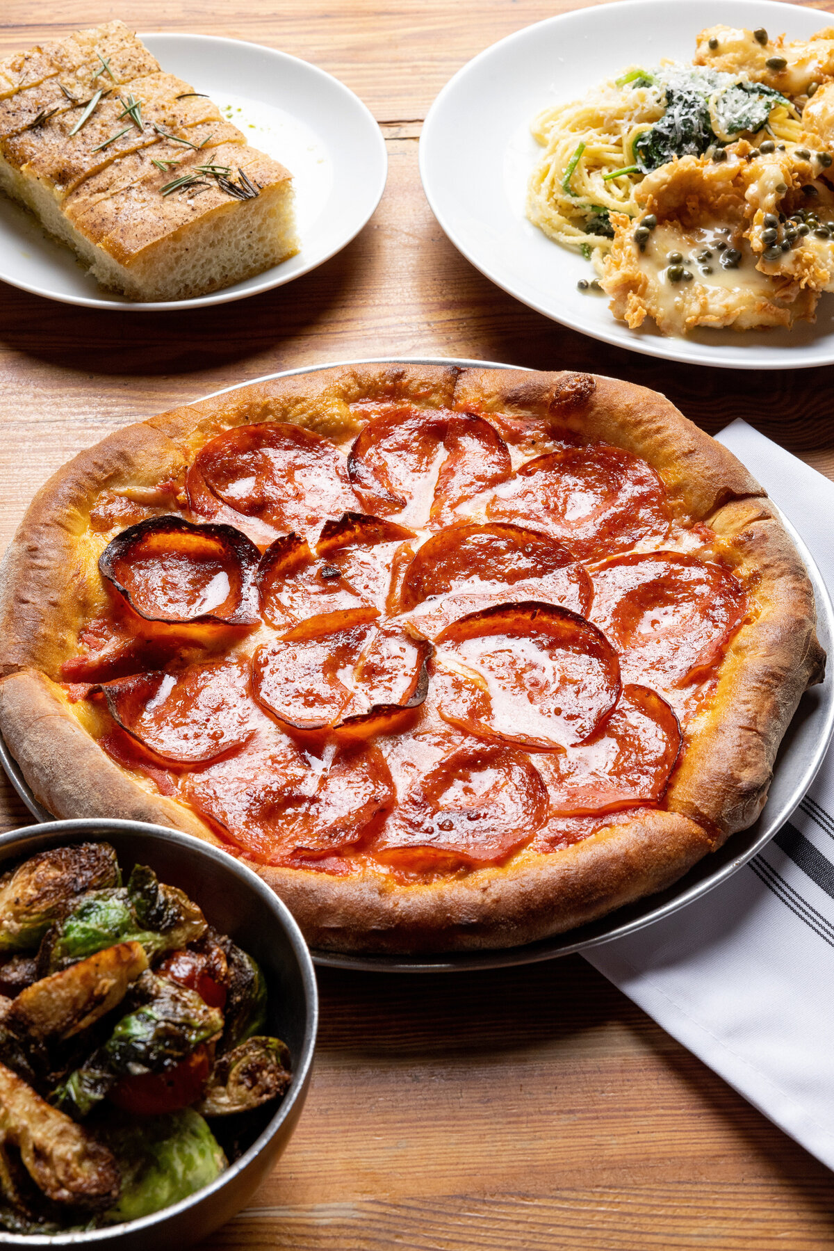 A pizza with side dishes on a table