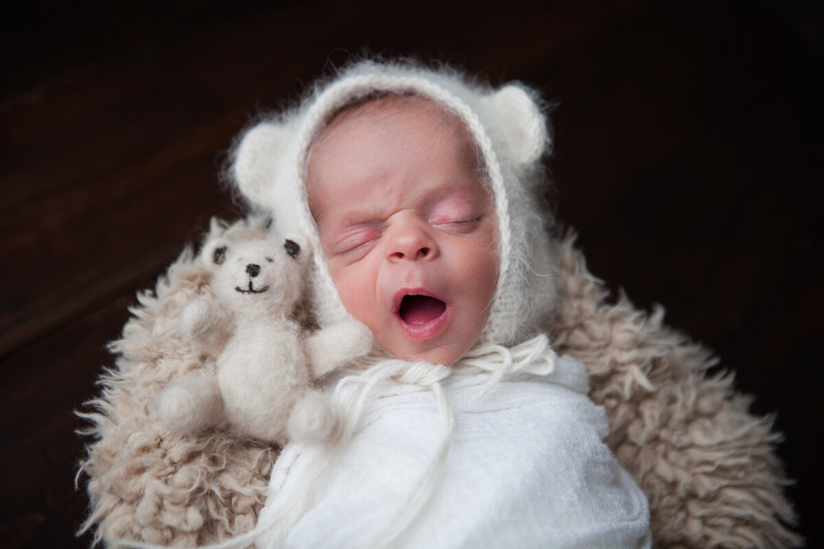 Newborn Baby Boy Yawning with Teddy Bear