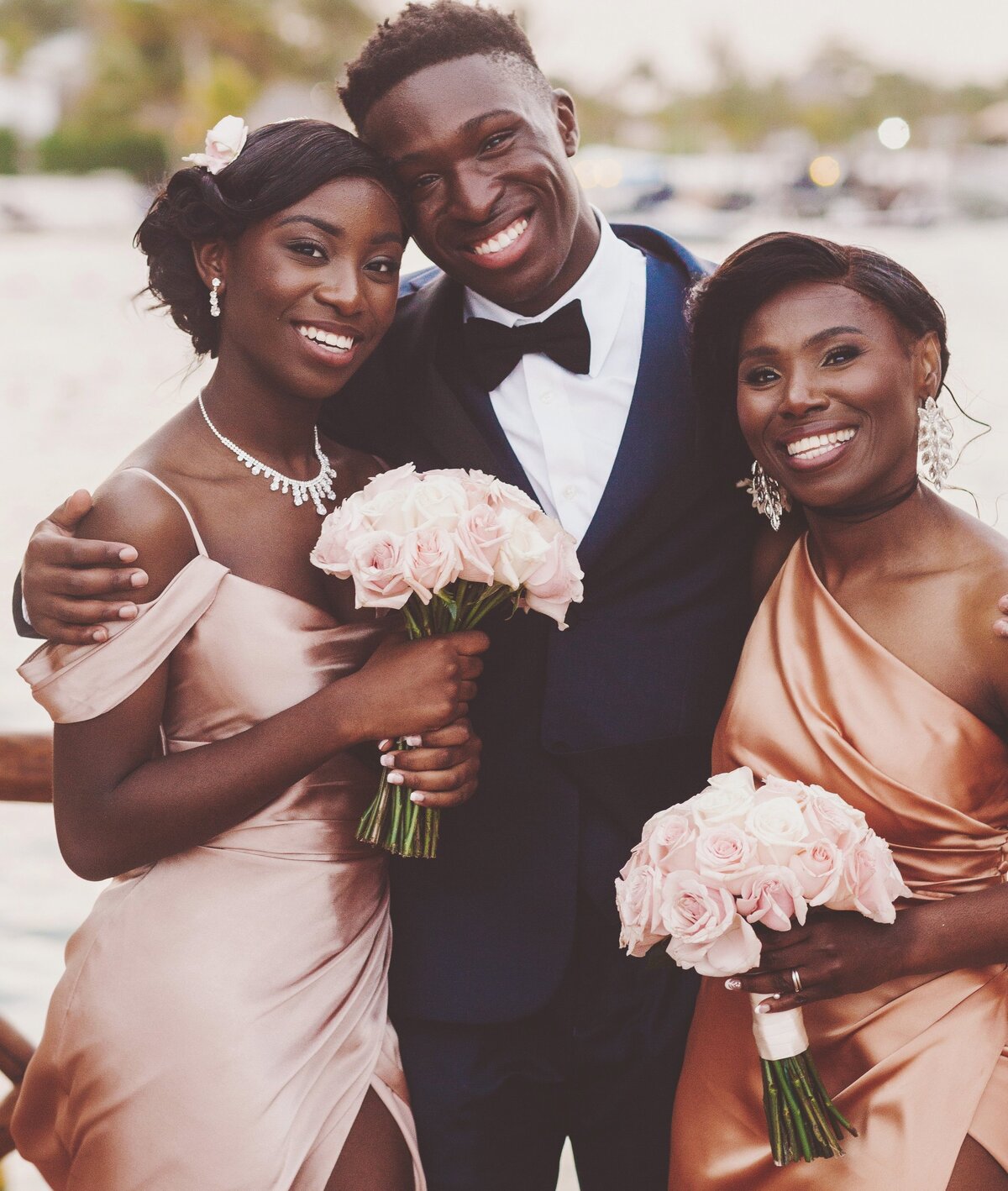 Groomsman with two bridesmaids at wedding in Cancun