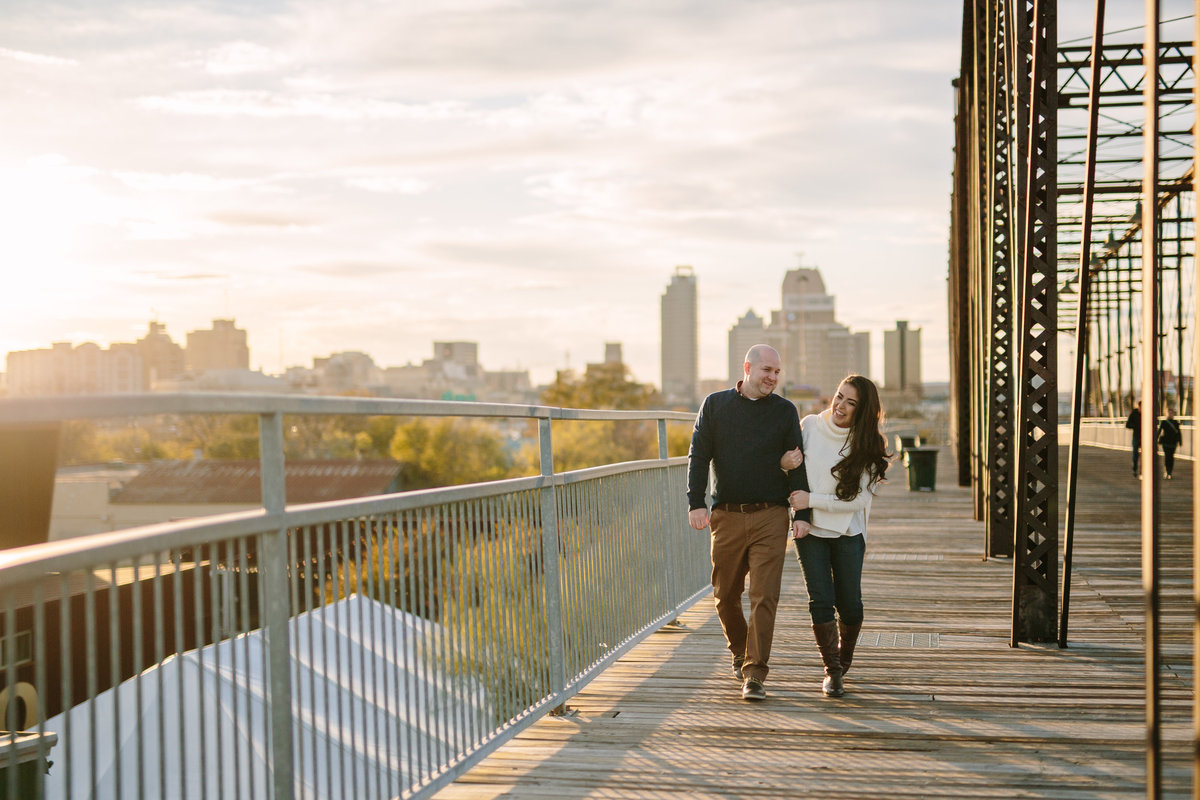 Man walking with women on Hays Street Bridge while on their engagement session with Expose The Heart Photography.